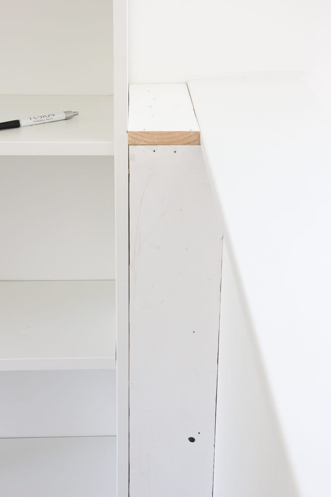 Filling a gap with a constructed box between a bookcase and a wall to make a built in shelf