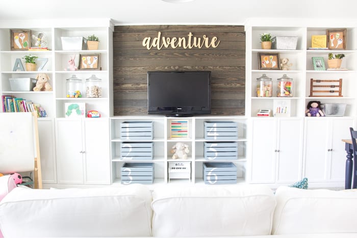 completed DIY built in bookshelves with wood blank wall in a playroom