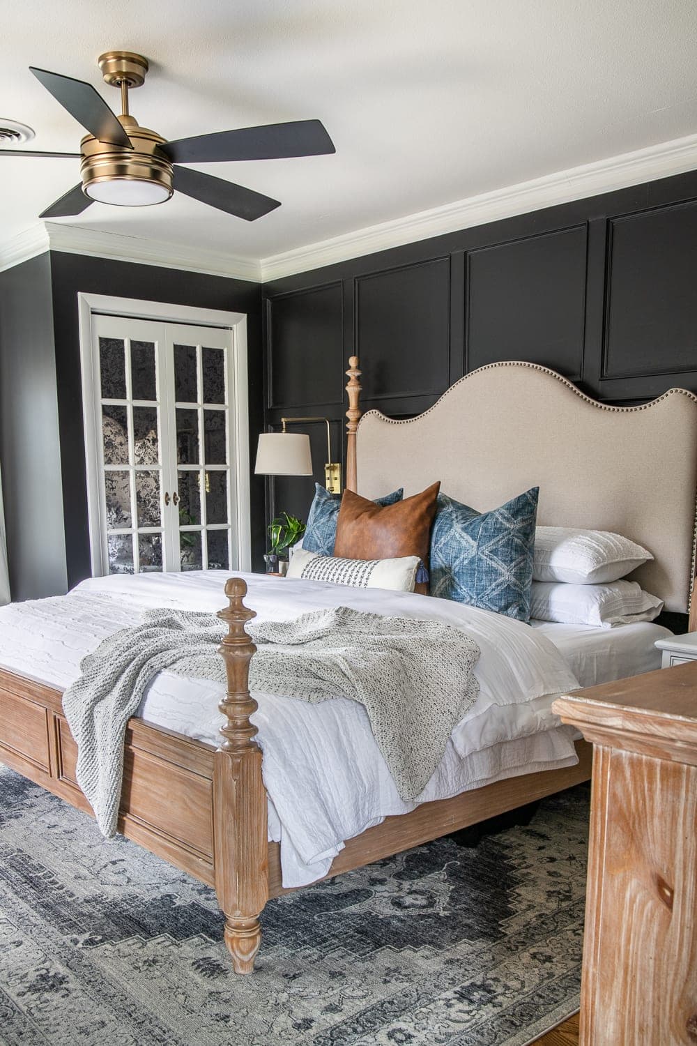 grid molding focal wall in a bedroom with French bed mirrored closet doors and black paint