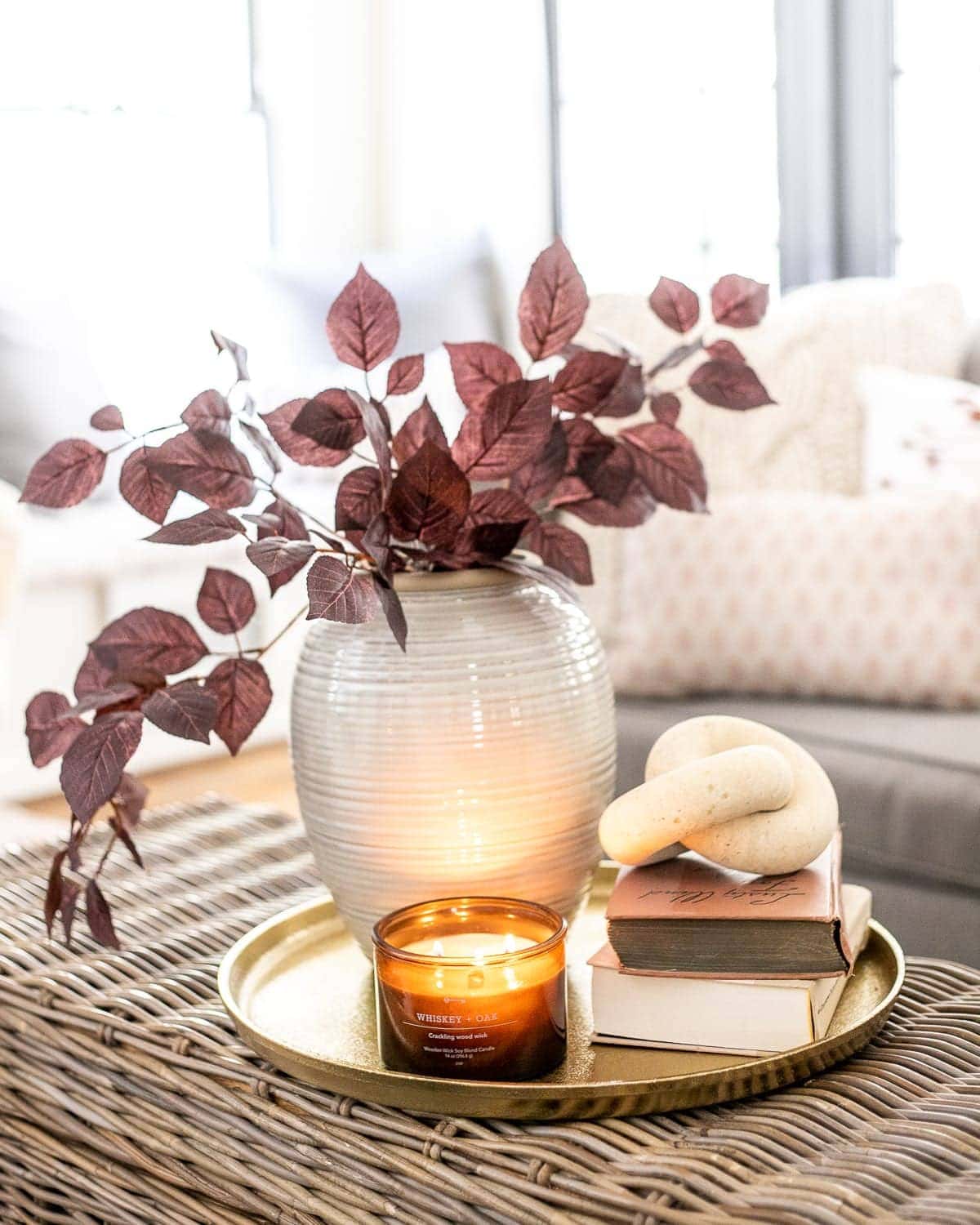 coffee table decor with tray, vase of fall branches, candle, and book stack