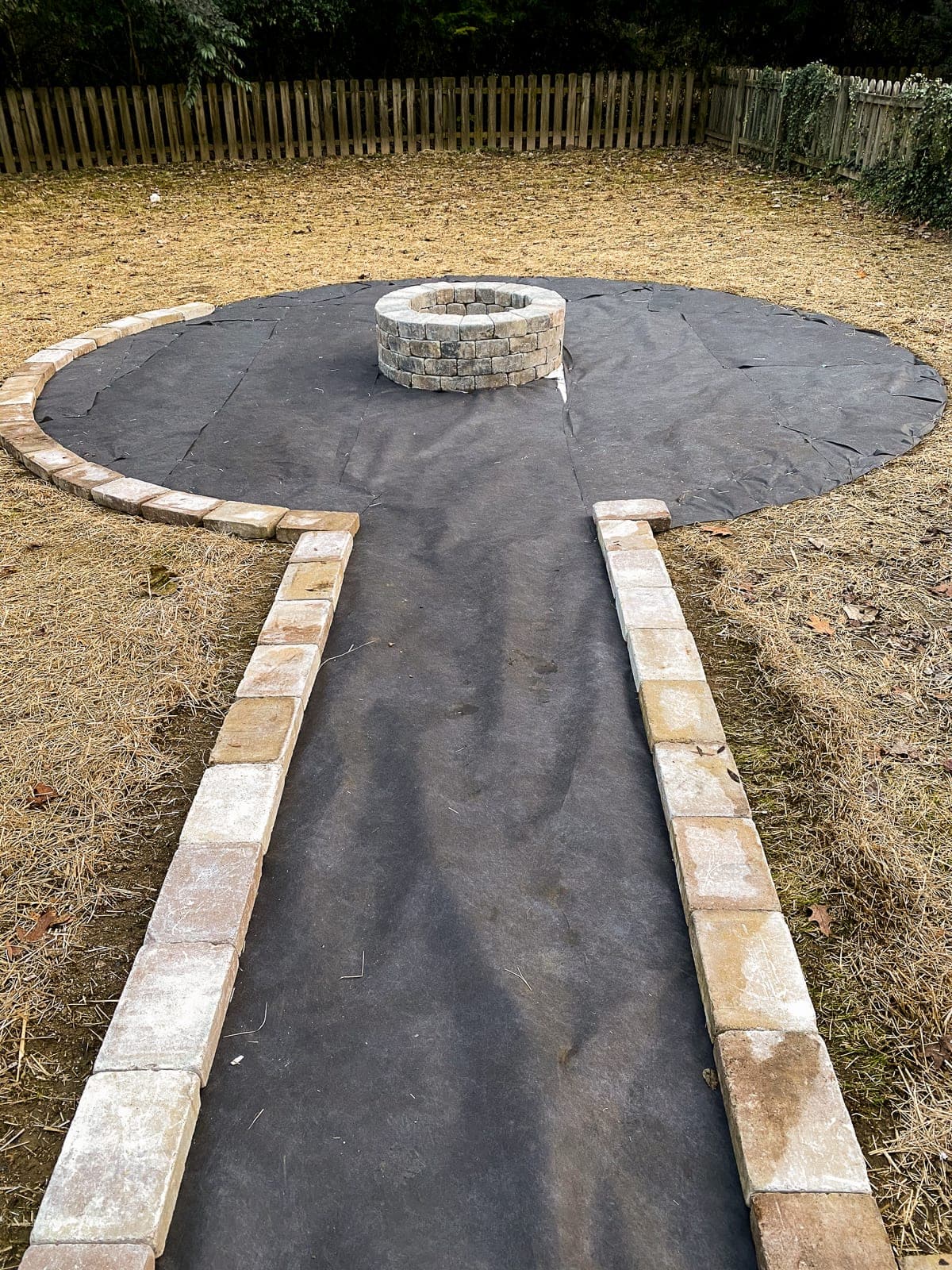 landscape fabric around a fire pit edged with stones