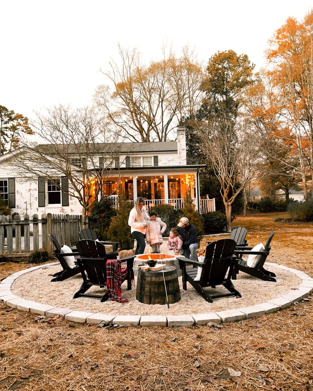 stone DIY fire pit with pea gravel and adirondack chairs